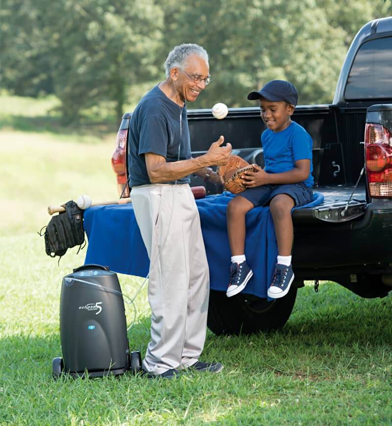 Eclipse 5 oxygen concentrator rental with active grandfather and grandson enjoying outdoor time together.
